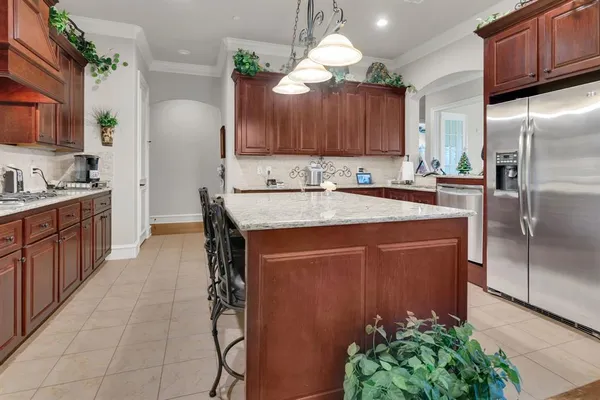 a kitchen with kitchen island granite countertop a stove a sink and a refrigerator