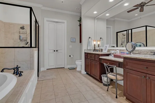 a spacious bathroom with a granite countertop sink a mirror and a bathtub