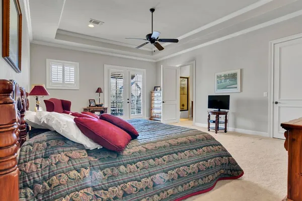 a bedroom with a large bed a chandelier and a couch