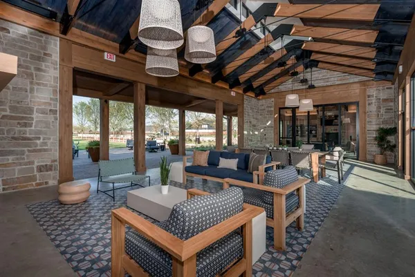 a outdoor space with lots of tables a large window and chairs