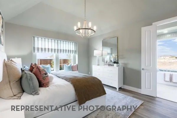 a bedroom with a large bed and a chandelier