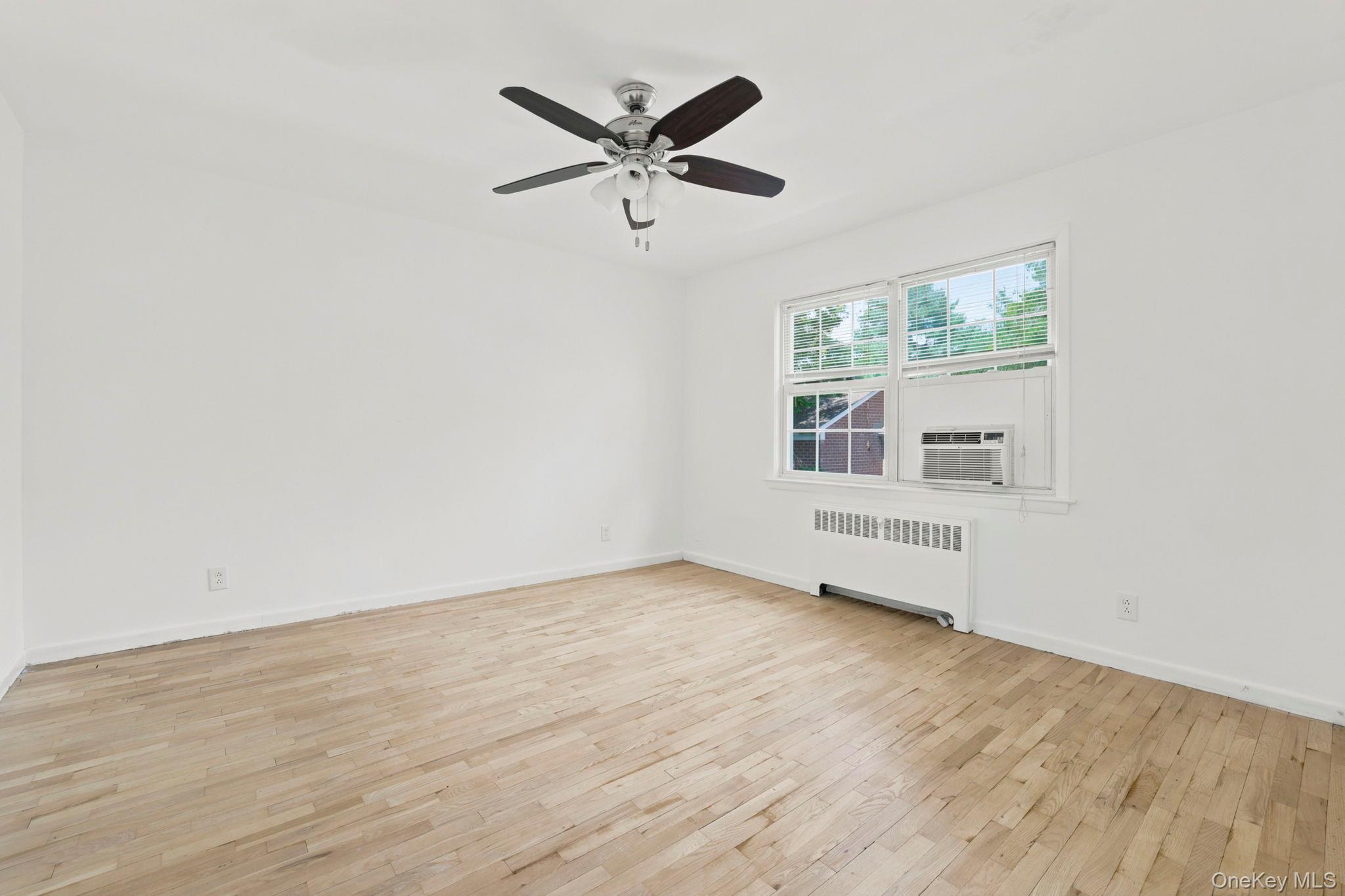 186 Pinewood Road, Unit 56 Hartsdale, NY 10530 - Photo 15 of 29 The bedroom has wood floors, a lighted ceiling fan, and wooded and courtyard views from the windows