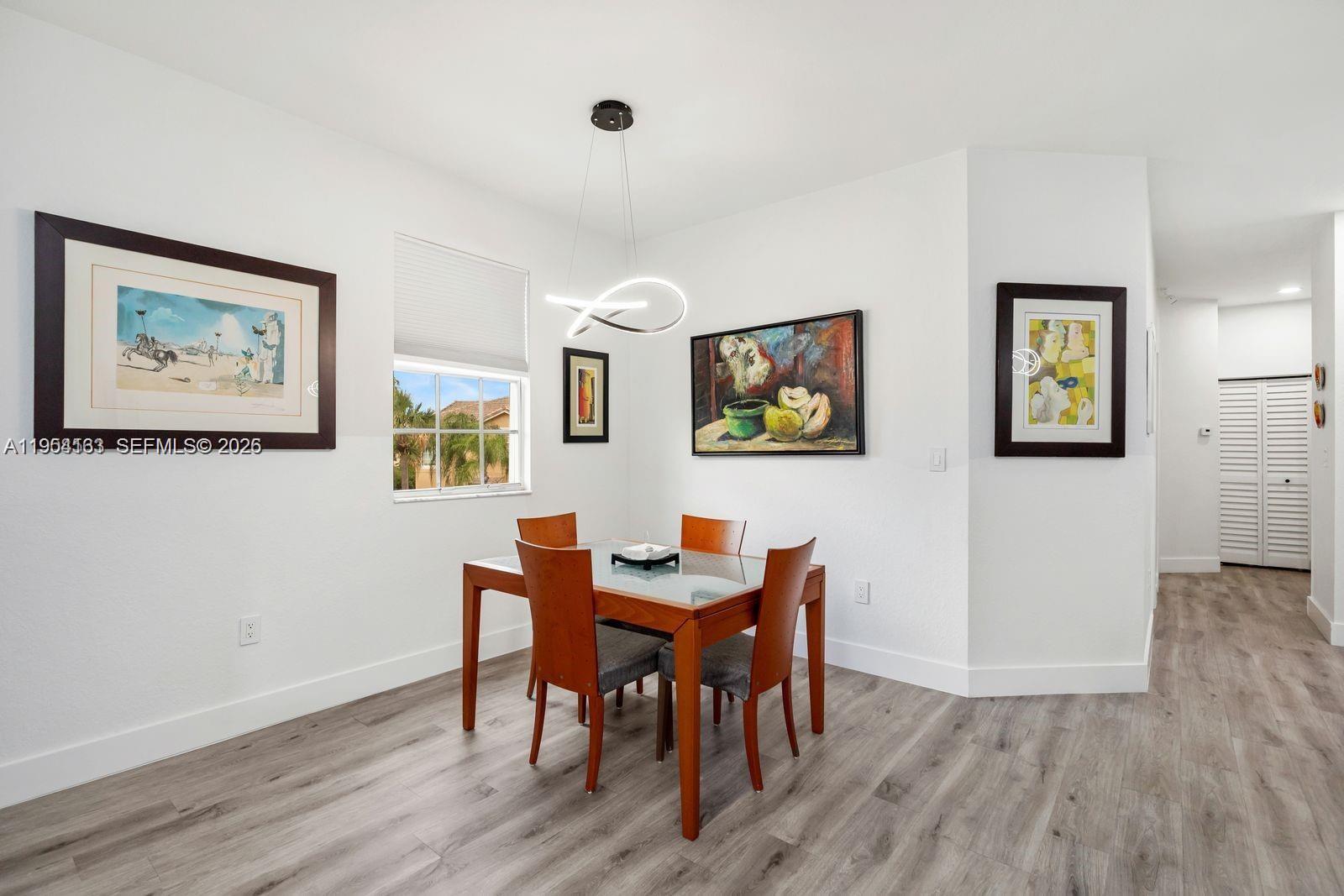 13216 Southwest 44th Street, Unit 11204 Miramar, FL 33027 - Photo 13 of 47 a view of a dining room with furniture and wooden floor