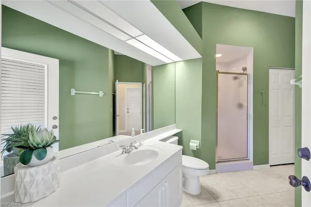a bathroom with a granite countertop sink a toilet and shower