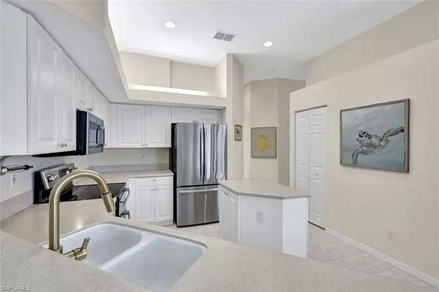 a kitchen with stainless steel appliances granite countertop a sink and a refrigerator