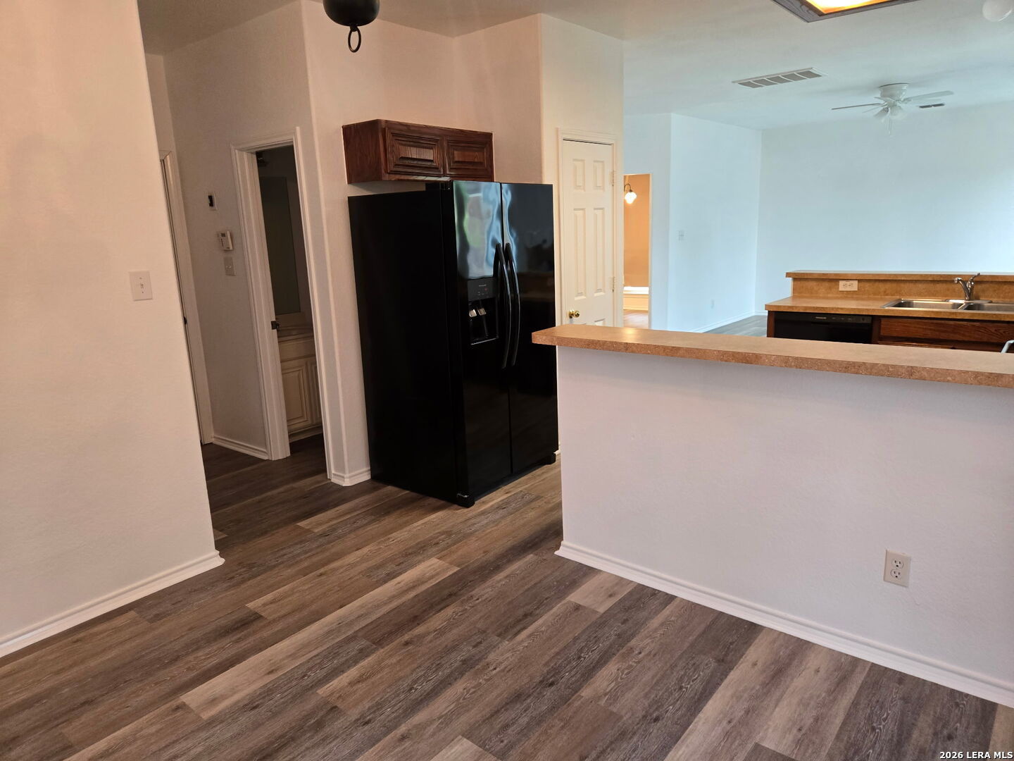 405 Point Valley San Antonio, TX 78253 - Photo 13 of 16 a view of a refrigerator in kitchen and an empty room with wooden floor