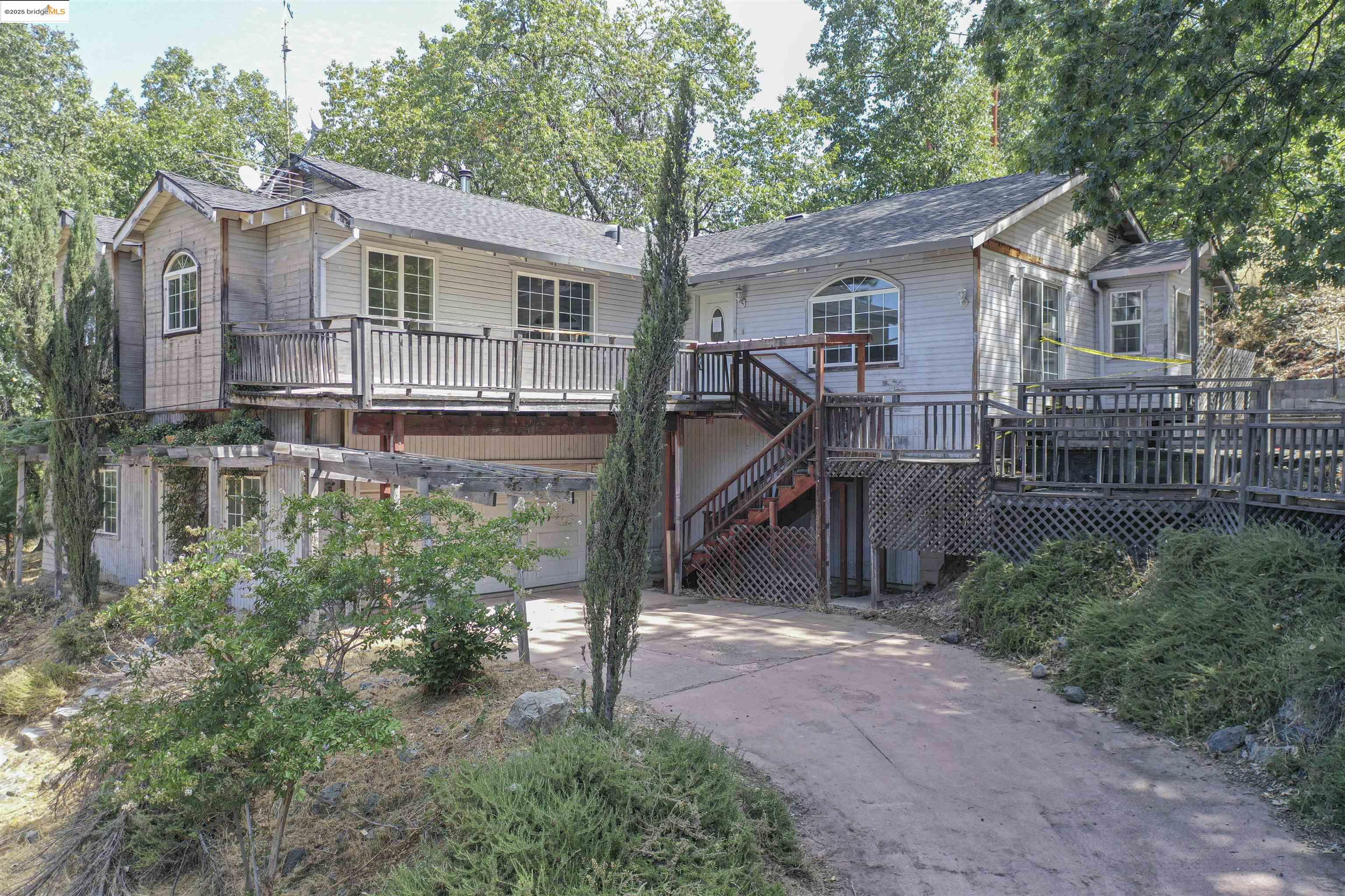a view of a house with a yard and large tree