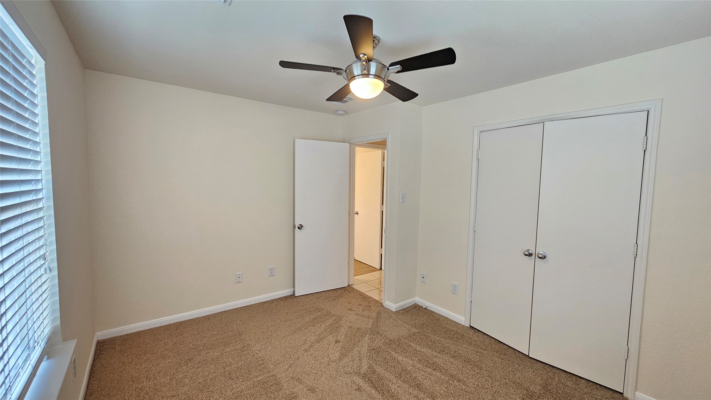 7918 Barnes Ridge Lane Houston, TX 77072 - Photo 11 of 34 This bedroom features neutral walls, a ceiling fan, and carpeted flooring. It has a window with blinds and a double-door closet.