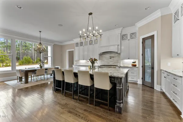 a view of a dining room and livingroom with furniture wooden floor a chandelier