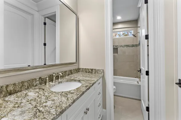 a bathroom with a granite countertop sink and a toilet