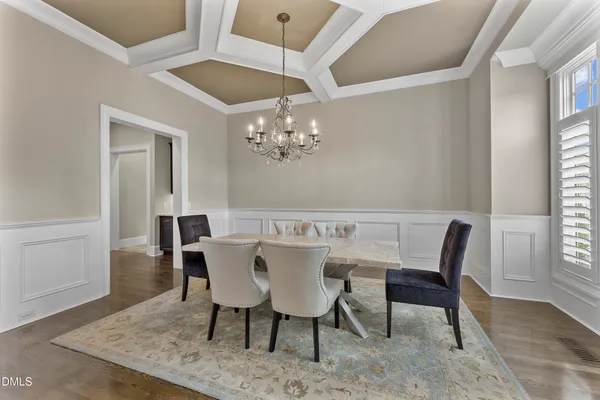a view of a dining room with furniture and a chandelier