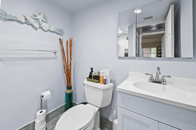 a bathroom with a sink a toilet a mirror and shower