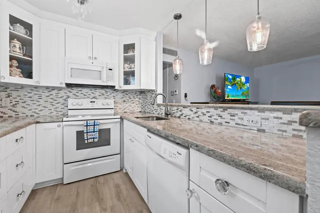 a kitchen with granite countertop white cabinets white stainless steel appliances and a granite counter tops