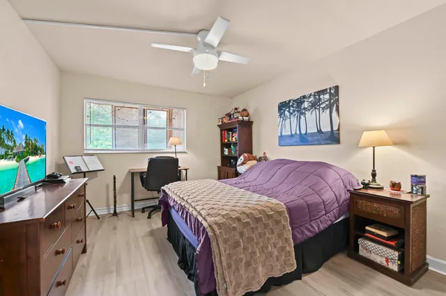 a bedroom with a bed and a dresser next to a window