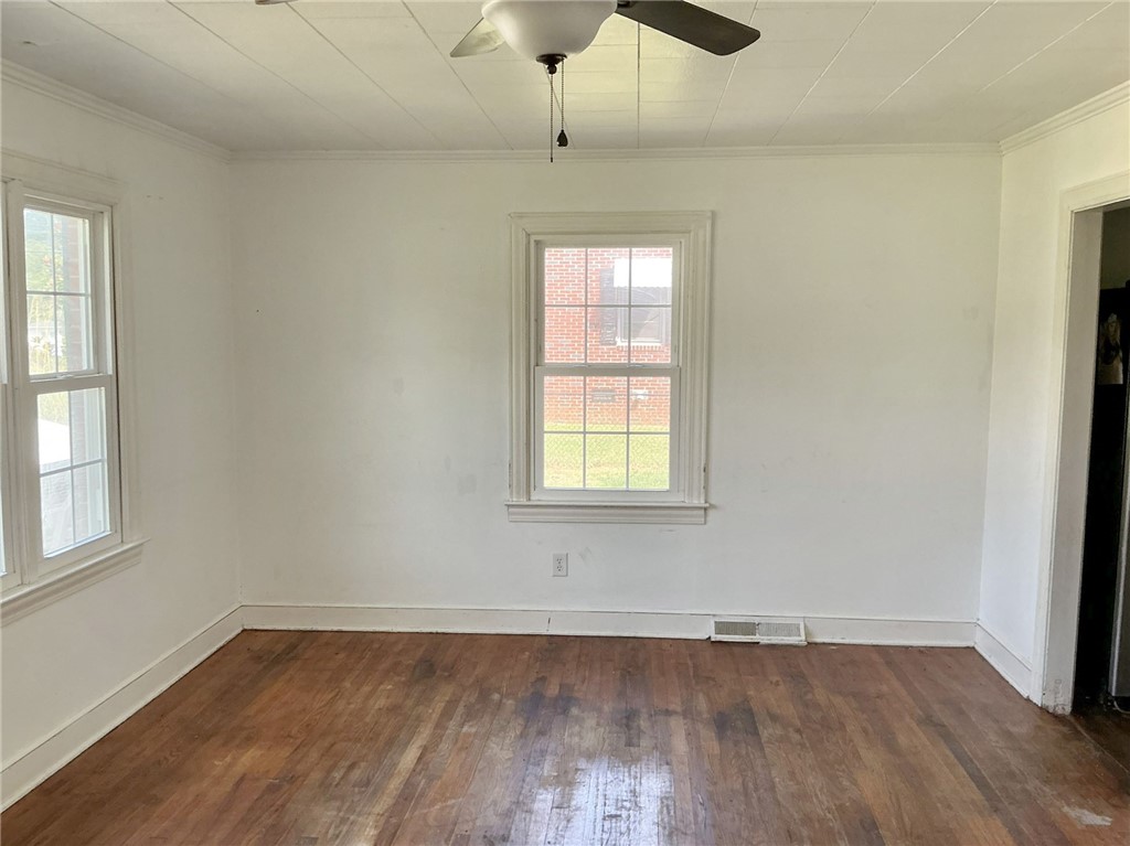 Rich hardwood floors and classic crown molding bring timeless character to this light-filled room.