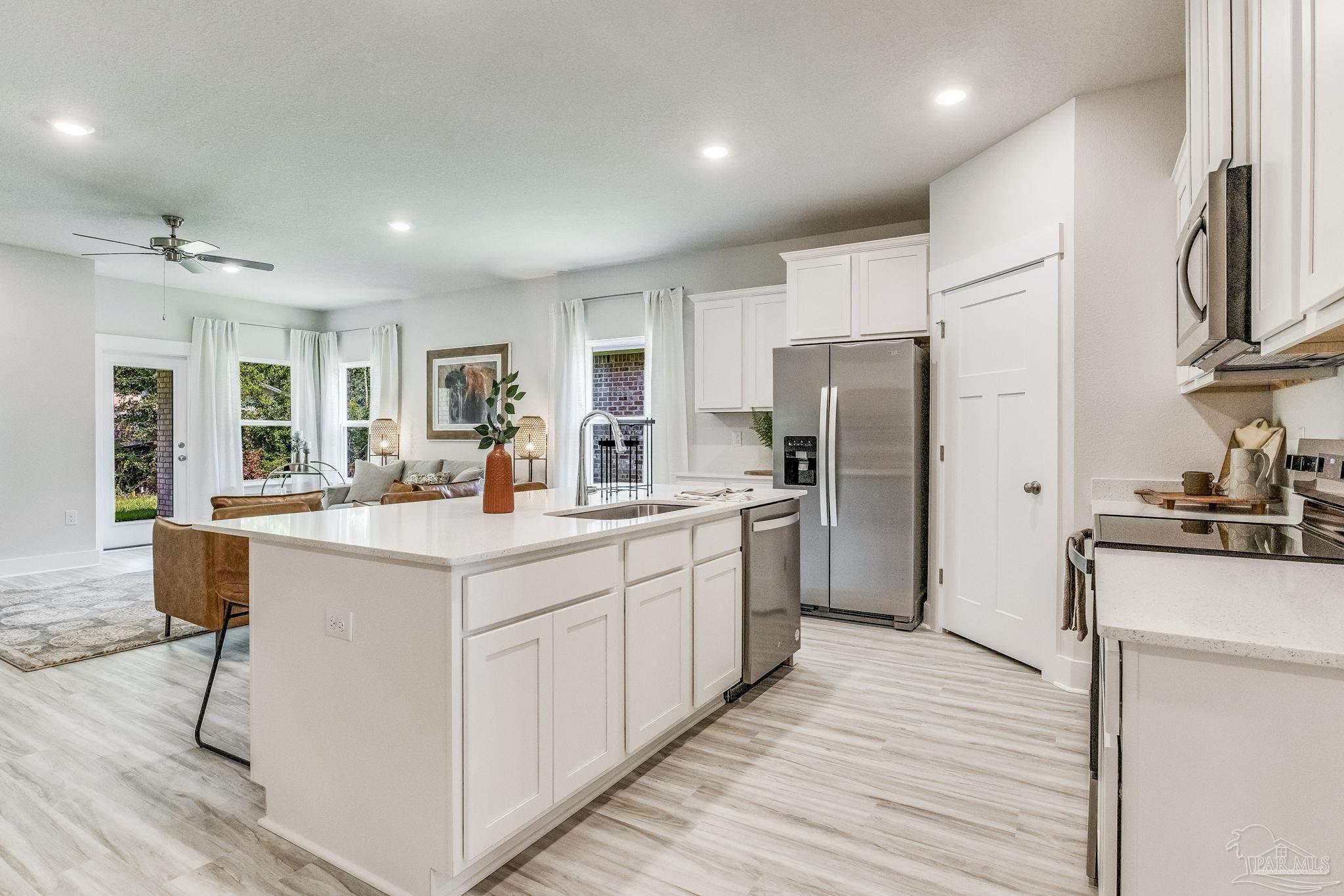 9793 Windy Hill Road Pensacola, FL 32526 - Photo 11 of 36 a kitchen with stainless steel appliances a sink stove refrigerator and cabinets