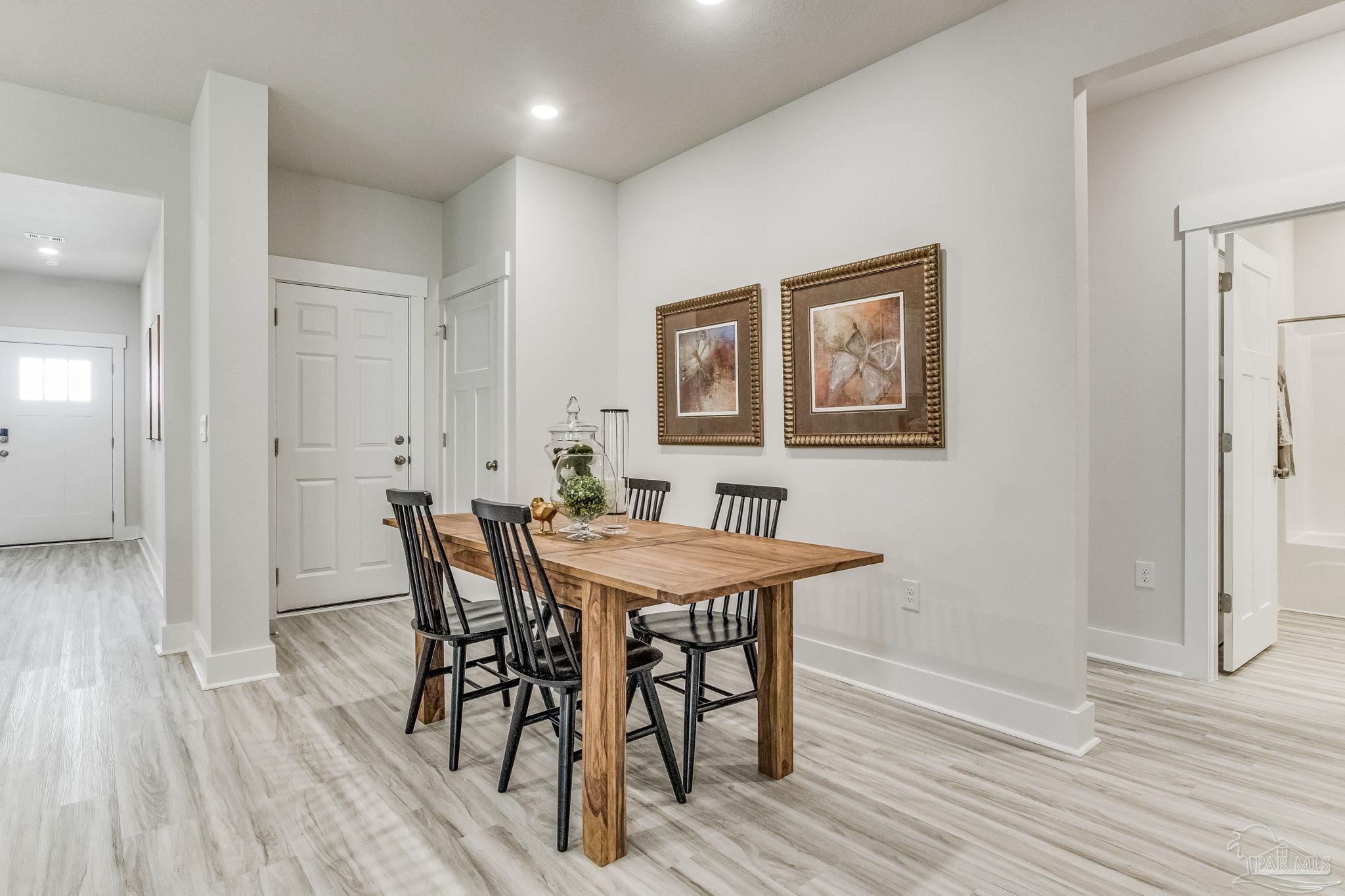 9793 Windy Hill Road Pensacola, FL 32526 - Photo 13 of 36 a view of a dining room with furniture and wooden floor