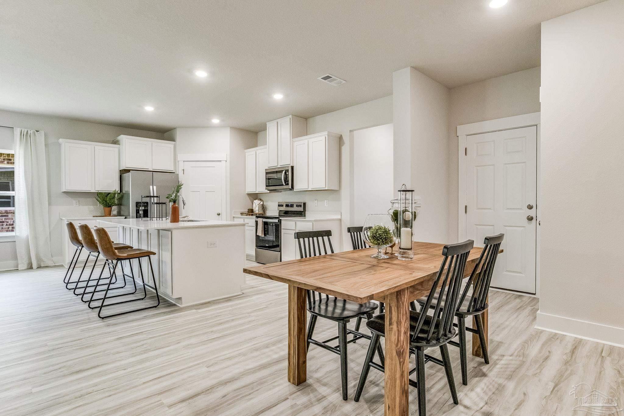 9793 Windy Hill Road Pensacola, FL 32526 - Photo 16 of 36 a kitchen with stainless steel appliances kitchen island granite countertop a dining table chairs and granite counter tops