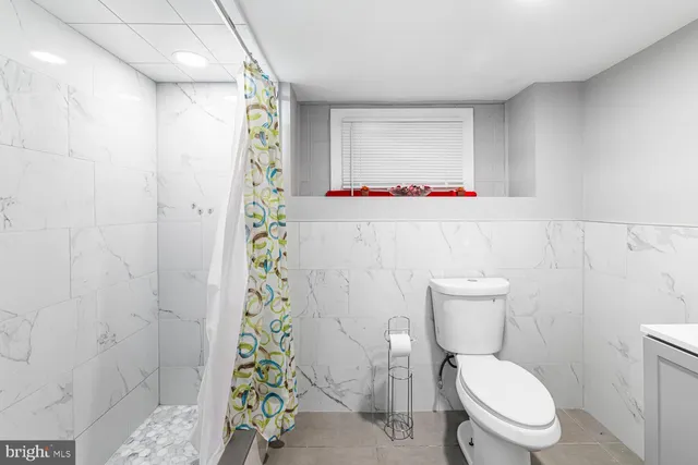 a white toilet sitting next to a shower curtain