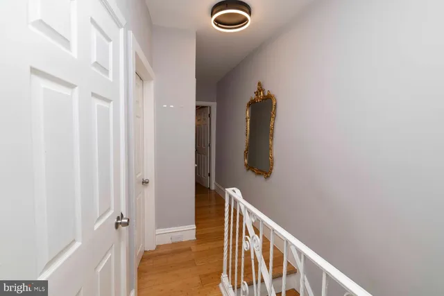 a view of a hallway with wooden floor and staircase