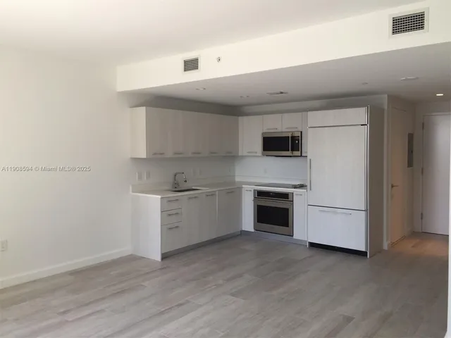a kitchen with granite countertop white cabinets and white appliances