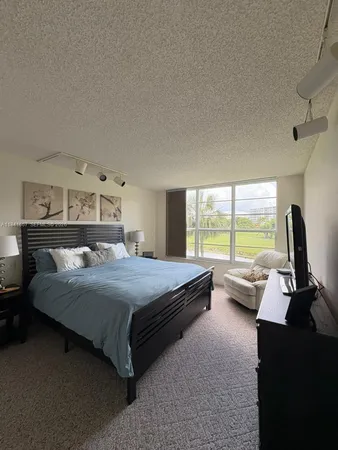 a bedroom with a bed and large windows