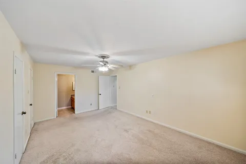 an empty room with a ceiling fan and a window