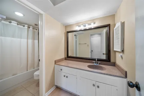 a bathroom with a granite countertop sink a toilet and a mirror
