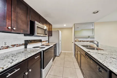 a kitchen with a stove sink and cabinets