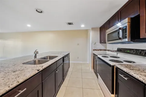 a kitchen with stainless steel appliances granite countertop a sink and dishwasher a stove top oven with wooden floor