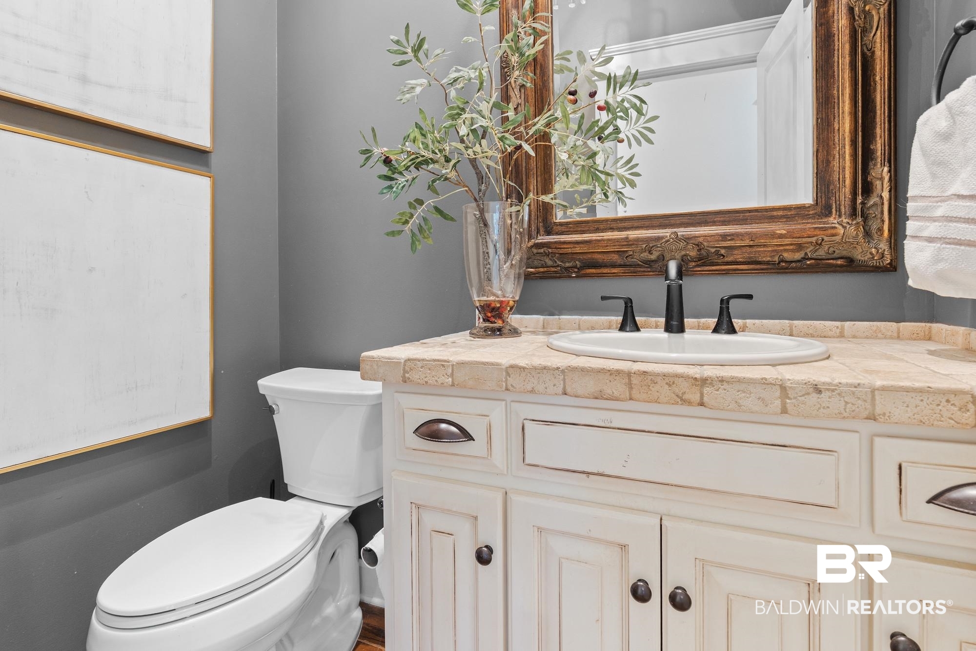 11261 Halcyon Loop Daphne, AL 36526 - Photo 28 of 41 White distressed vanity with dark bronze hardware, a tiled countertop, and an undermount sink with a matte black faucet