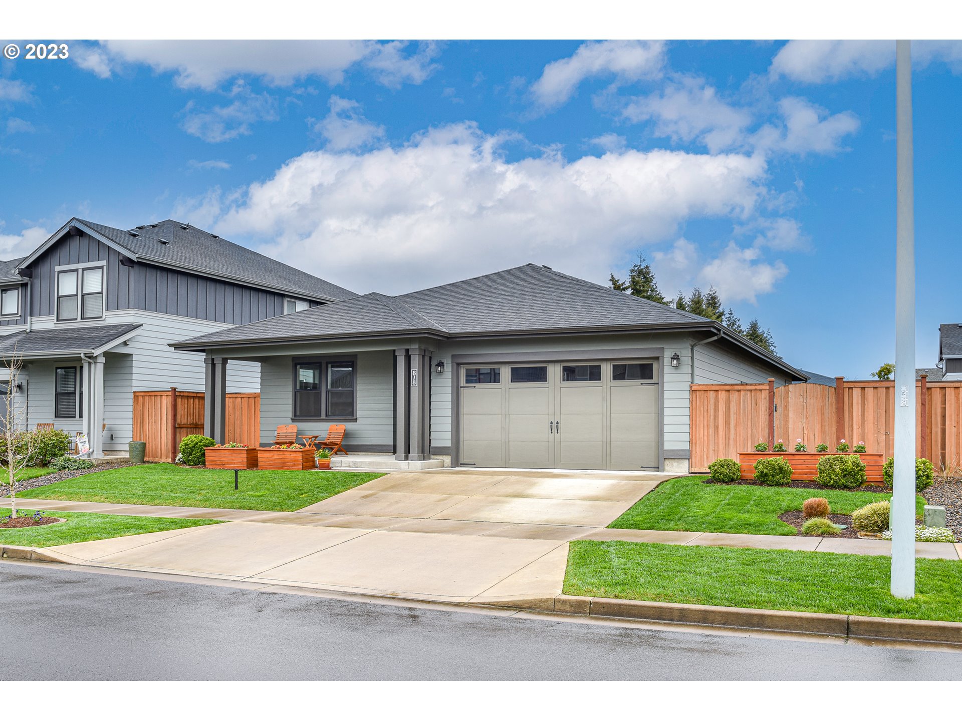 a front view of a house with a yard and potted plants