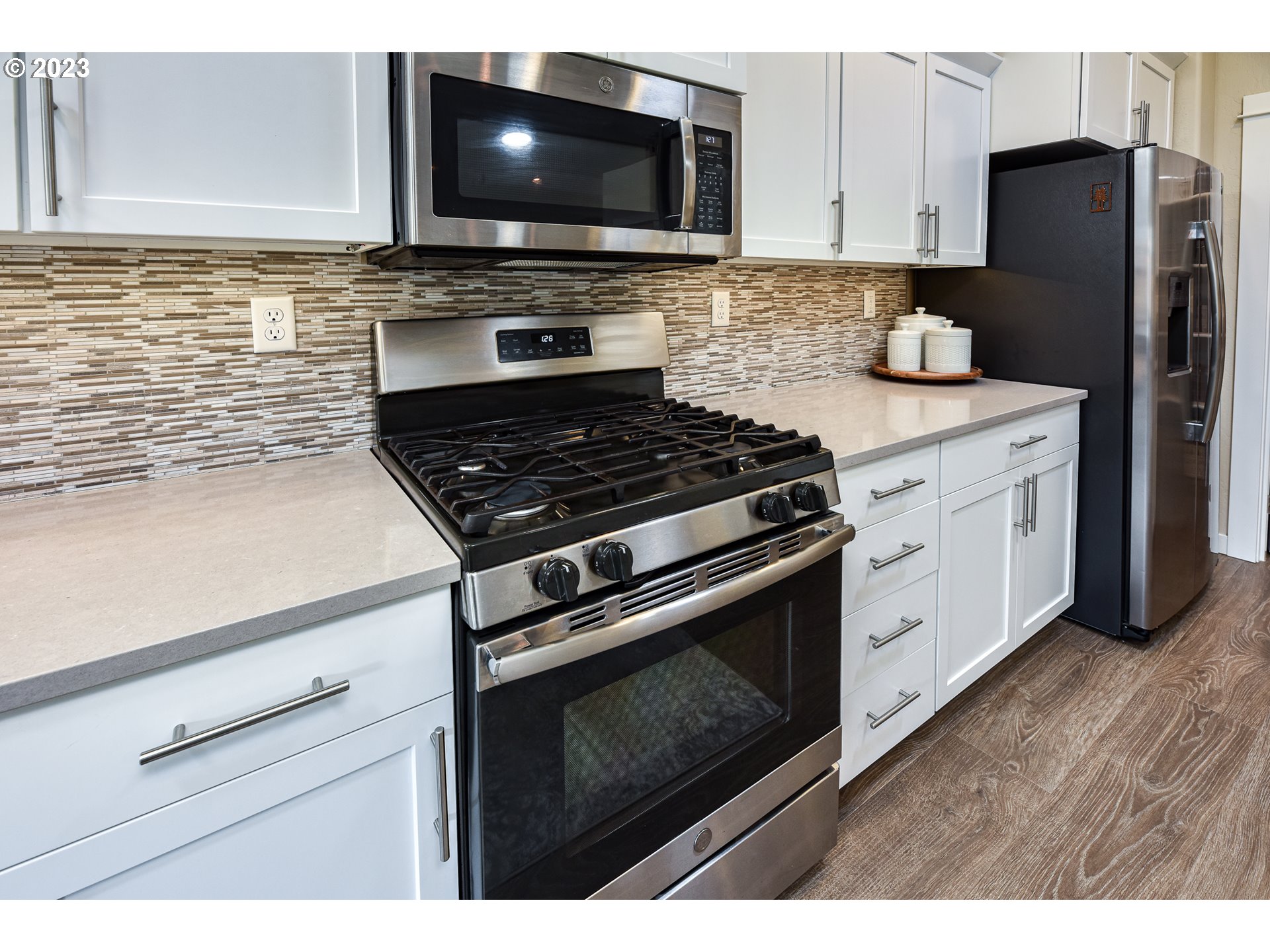 878 Tyson Lane Eugene, OR 97404 - Photo 11 of 39 a kitchen with stainless steel appliances a stove a microwave a sink and cabinets