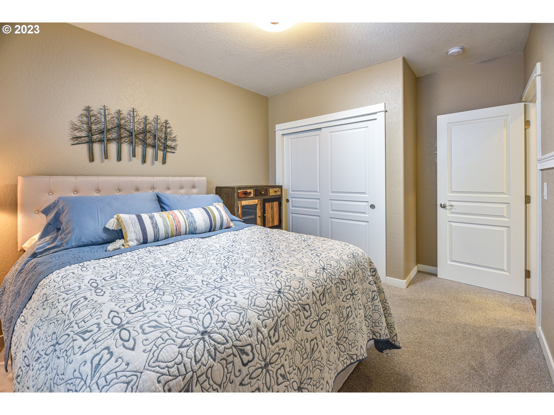 878 Tyson Lane Eugene, OR 97404 - Photo 24 of 39 a bedroom with a large bed and a chandelier
