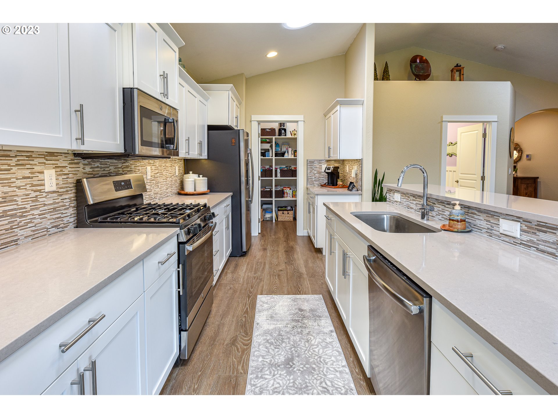 878 Tyson Lane Eugene, OR 97404 - Photo 10 of 39 a kitchen with stainless steel appliances kitchen island granite countertop a sink stove and cabinets