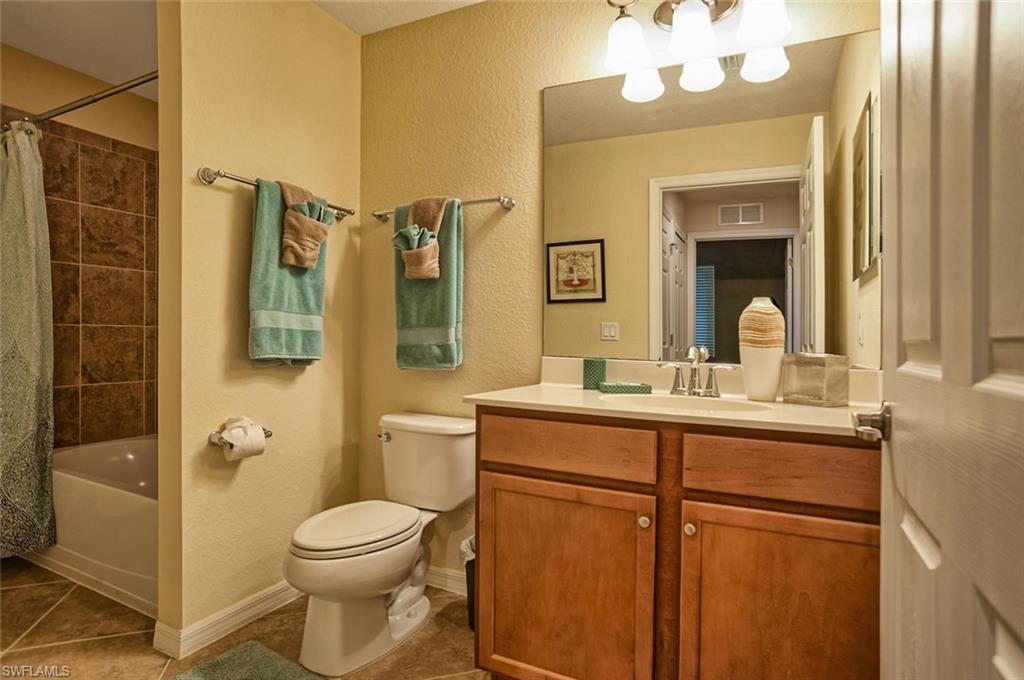9727 Acqua Court, Unit 425 Naples, FL 34113 - Photo 14 of 26 a bathroom with a toilet a sink and a mirror