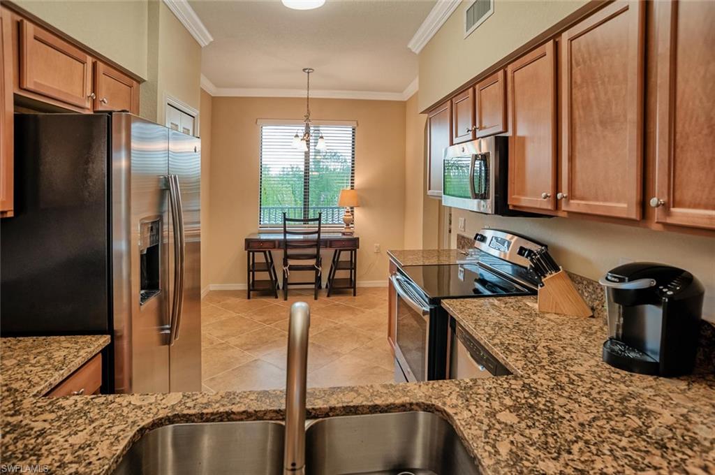9727 Acqua Court, Unit 425 Naples, FL 34113 - Photo 6 of 26 a kitchen with stainless steel appliances granite countertop a refrigerator a stove and a sink