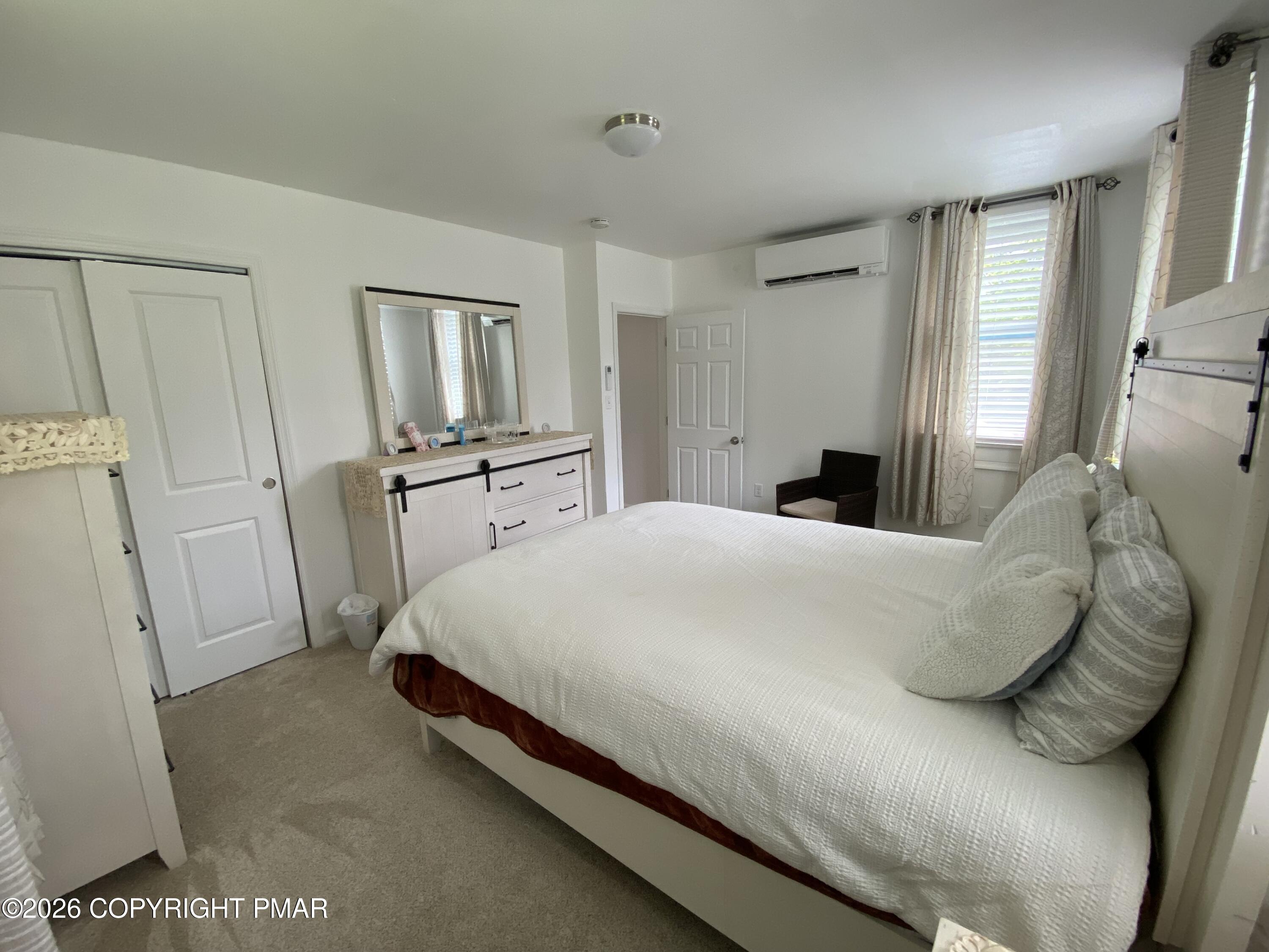 565 Cherry Lane Road East Stroudsburg, PA 18301 - Photo 13 of 16 a large bed sitting in a bedroom and chair next to a window