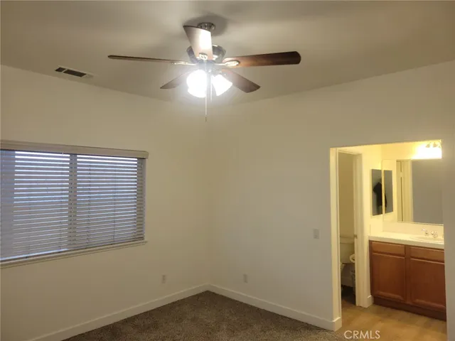 an empty room with chandelier fan