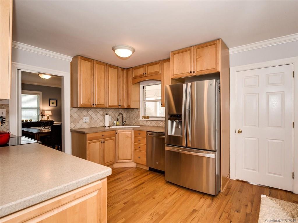 935 Scaleybark Road Charlotte, NC 28209 - Photo 7 of 17 a kitchen with a refrigerator a stove top oven and wooden floor