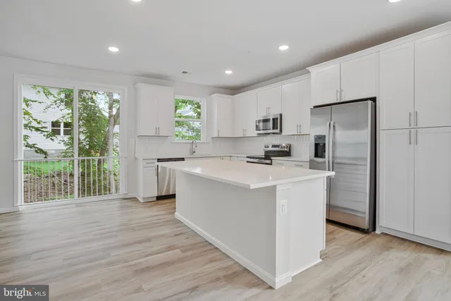 a kitchen with stainless steel appliances a refrigerator stove and microwave