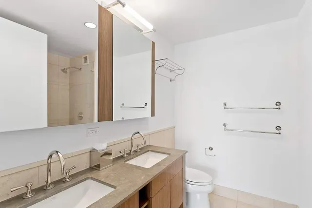 a bathroom with a granite countertop sink a toilet and a mirror