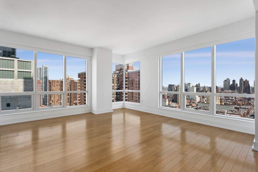 350 West 42nd Street, Unit 36B Manhattan, NY 10036 - Photo 2 of 17 a view of an empty room with a window and wooden floor