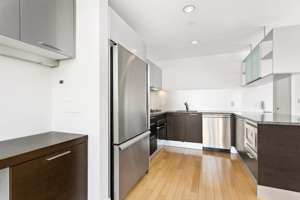 350 West 42nd Street, Unit 36B Manhattan, NY 10036 - Photo 5 of 17 a kitchen with stainless steel appliances a refrigerator and a sink