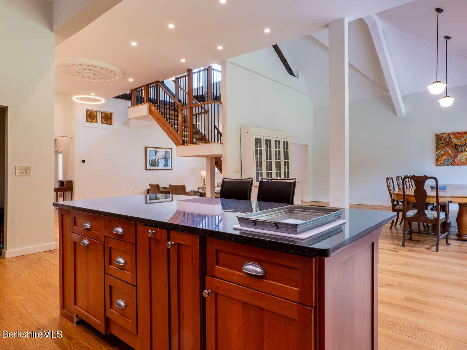 160 High Street Lee, MA 01238 - Photo 22 of 41 a kitchen with stainless steel appliances granite countertop a sink dishwasher a stove and a dining table with wooden floor