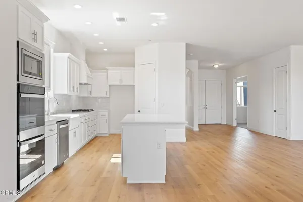 a large kitchen with stainless steel appliances granite countertop a large counter top and a stove top oven
