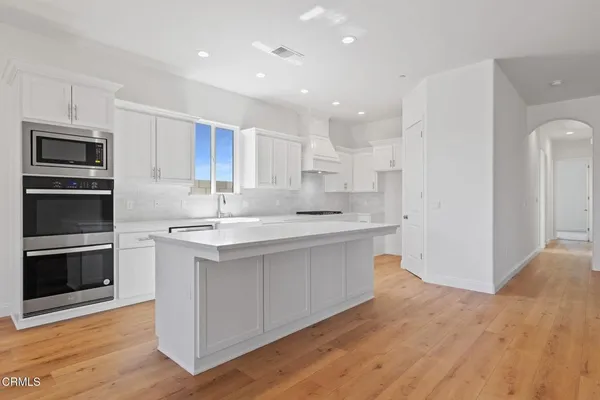 a kitchen with stainless steel appliances granite countertop a stove top oven a sink and a microwave