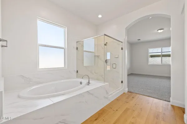 a spacious bathroom with a bathtub shower and sink