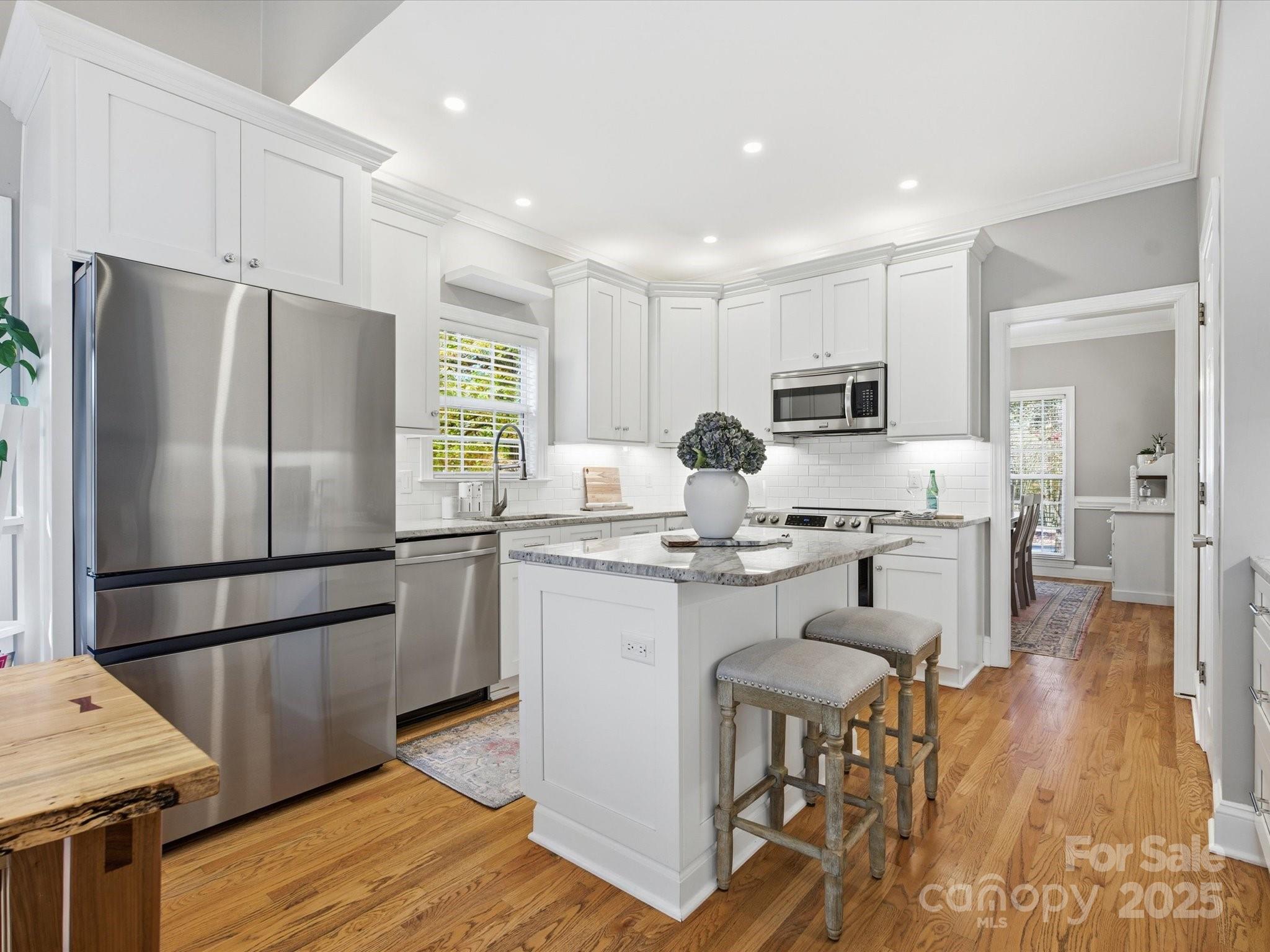 4601 Magnolia Ridge Drive Waxhaw, NC 28173 - Photo 11 of 48 a kitchen with kitchen island white cabinets and stainless steel appliances