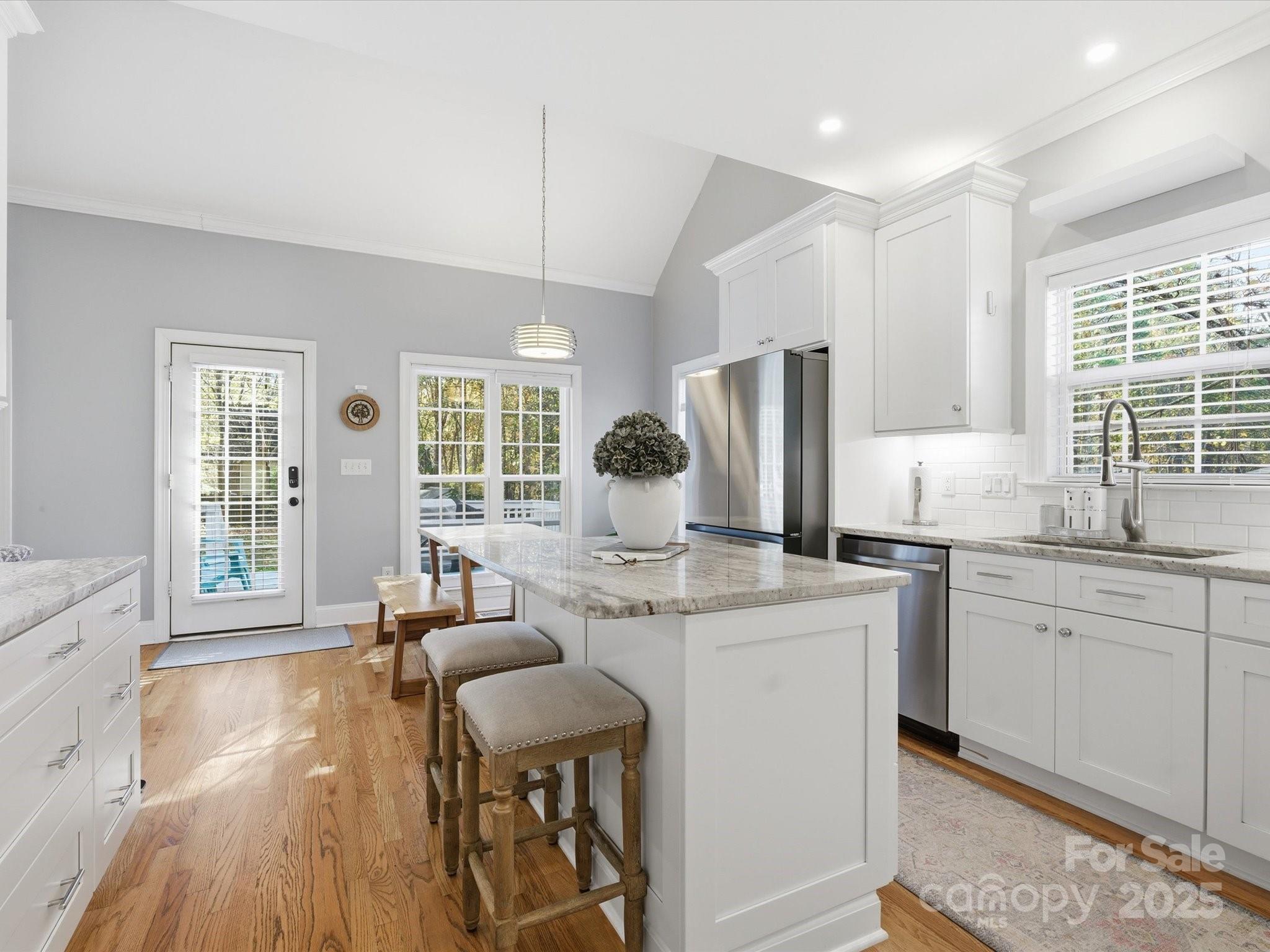 4601 Magnolia Ridge Drive Waxhaw, NC 28173 - Photo 8 of 48 a kitchen with stainless steel appliances granite countertop a stove a refrigerator a sink dishwasher and white cabinets with wooden floor